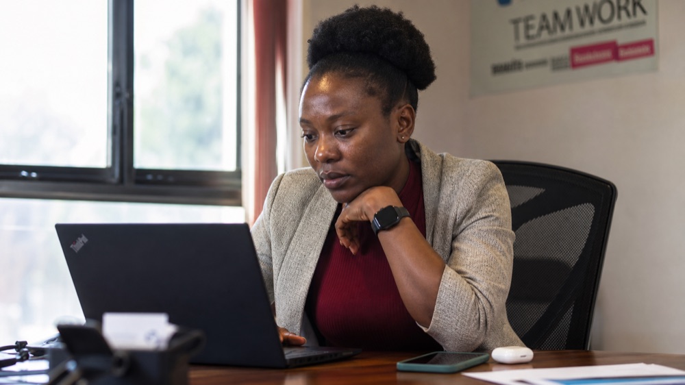Zimbabwean professional working with an AI assistant on a laptop during the AI Essentials course