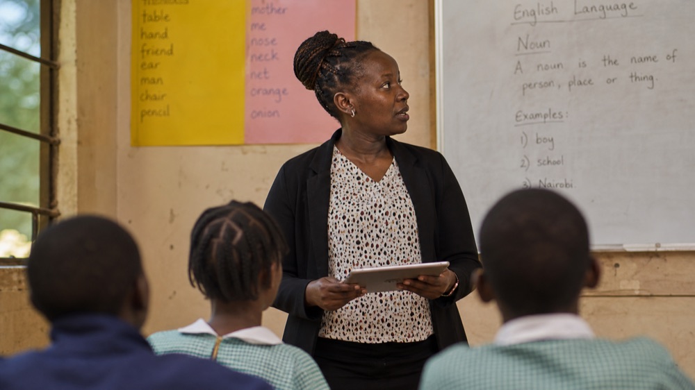 Teacher using a tablet in front of her class during the AI for Educators course