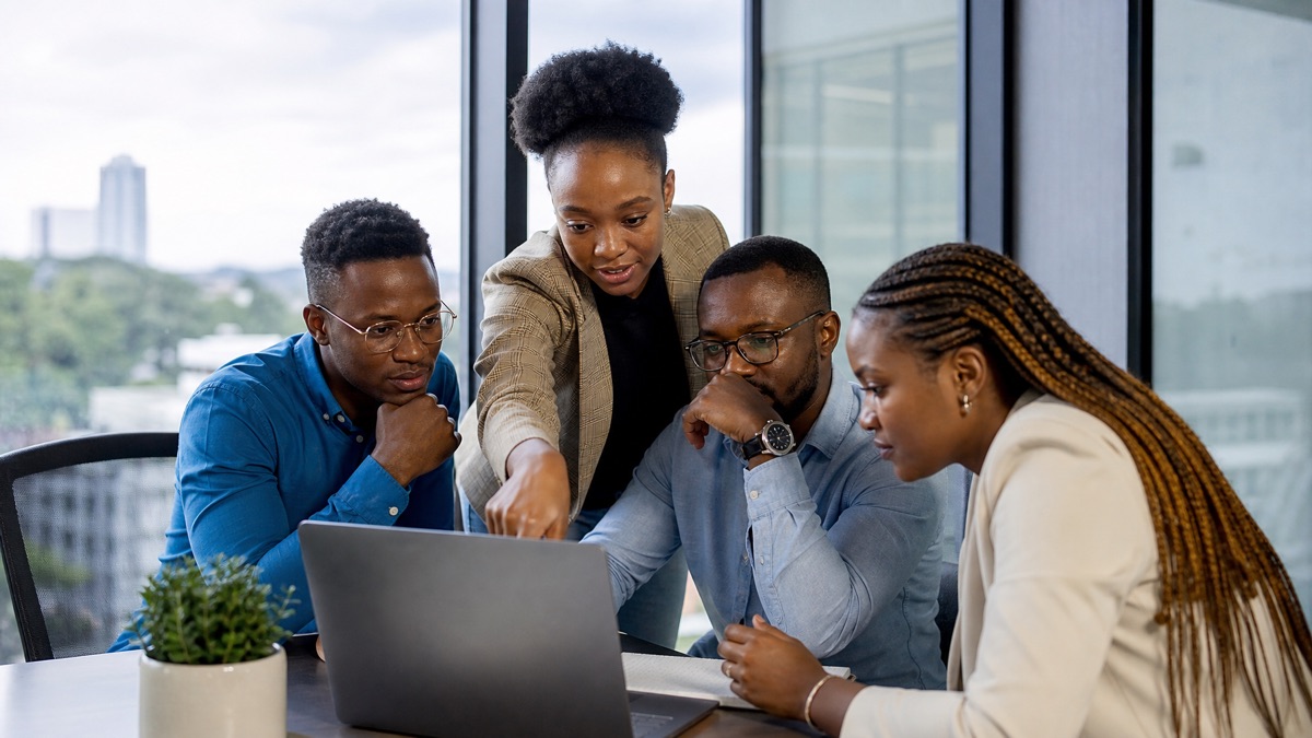 A small diverse team collaborating around a shared laptop, representing the Digital & Specialised Skills category